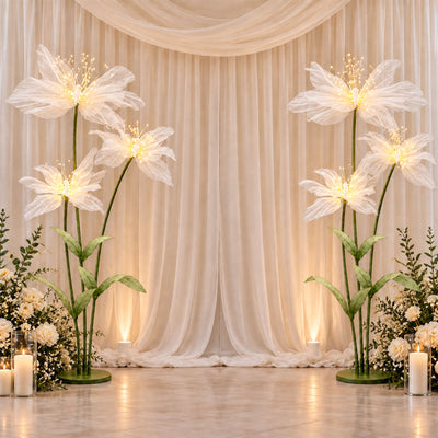 Elegant white floral wedding backdrop with glowing butterfly light decorations