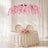 Elegant blush pink floral wedding table with cherry blossom canopy under soft drapes