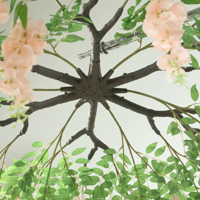 Floral chandelier with branches and pink flowers, viewed from below.