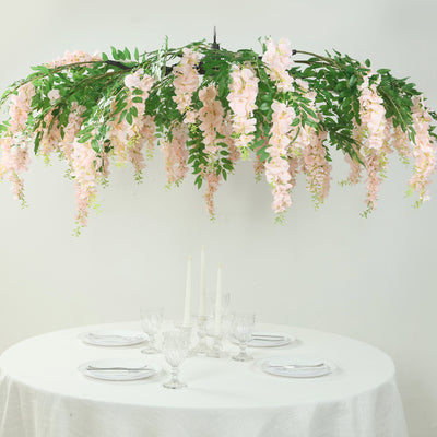 Elegant pink floral chandelier above a dining table setting.