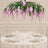 Elegant round table with white tableware, candles, and pink floral chandelier centerpiece