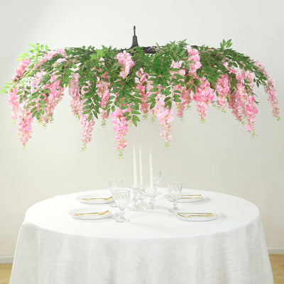Pink floral chandelier centerpiece over a dining table setting.