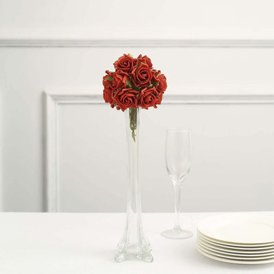 Red rose bouquet in a glass vase with elegant tableware.