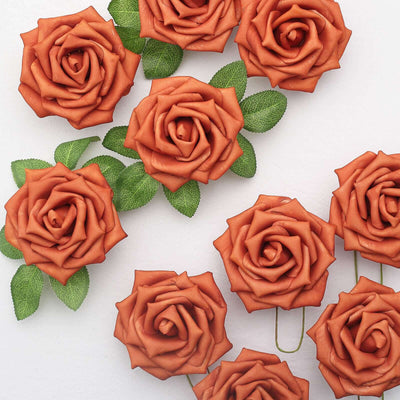 Brown clay rose paper clips with green leaves on a white background.
