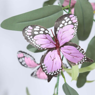 Pink butterfly decoration with detailed wings and green leaves