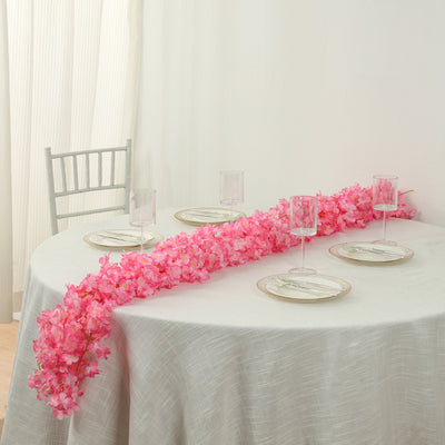 Elegant pink floral table centerpiece with clear glassware and dinner plates.