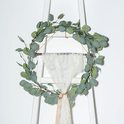 Eucalyptus wreath with lace and ribbon on a decorative ladder