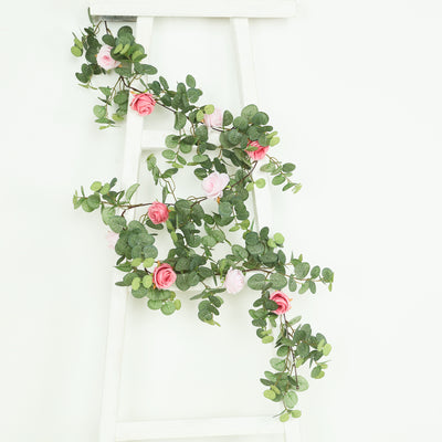 Artificial greenery with pink roses on a white ladder