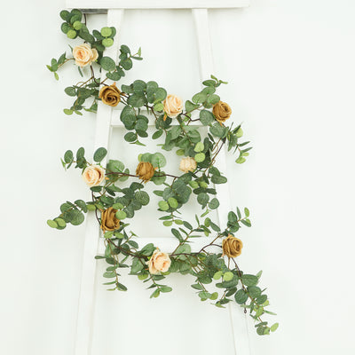 Artificial floral garland with roses and eucalyptus on a white ladder