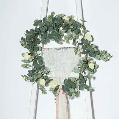 Eucalyptus and rose floral wreath on a white wooden ladder