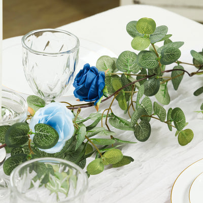 Blue and teal artificial rose garland on a dining table setting.