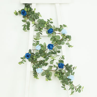 Artificial blue and white flower garland on a white ladder.