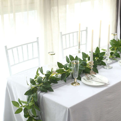 Elegant table setting with greenery and candles for a sophisticated dining experience.