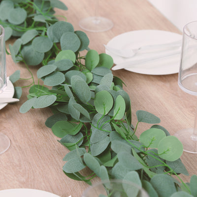 Eucalyptus garland centerpiece on a dining table setting.