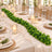 Elegant wedding reception table with candles, greenery, and gold chairs