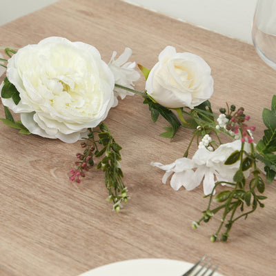 Artificial white flowers arrangement on wooden table.