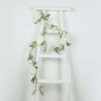 White floral garland draped over a white ladder