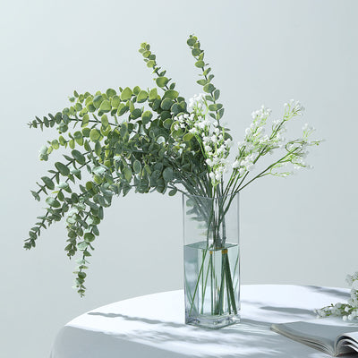 Elegant floral arrangement in a glass vase with greenery and white flowers