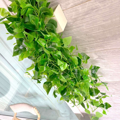 Artificial green vine plant with lush leaves for home decor.