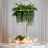 Hanging fern centerpiece above an elegantly set table with candles and glassware.