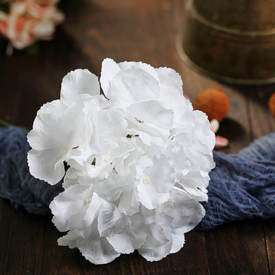 White artificial flower bouquet on a rustic wooden surface.