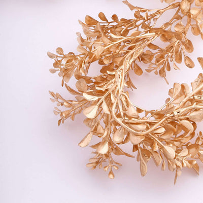 Dried golden leaves wreath on a light background