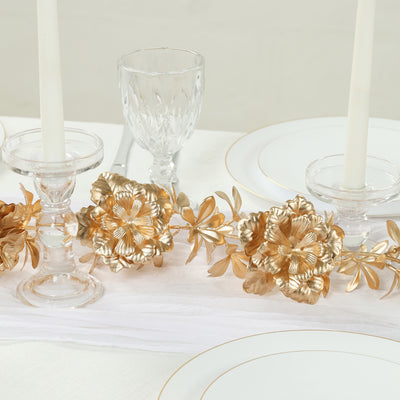 Gold floral table centerpiece with crystal candle holders and elegant dinnerware.