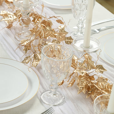 Elegant table setting with crystal glassware and gold leaf garland.
