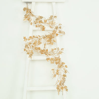 Gold ivy garland draped on a white ladder