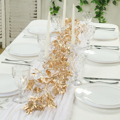 Elegant table setting with gold leaf centerpiece and crystal glassware.