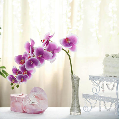 Purple orchid in a vase with decorative box in a bright, elegant setting.