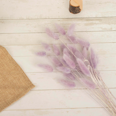 Purple dried flower bouquet on a wooden table with burlap.