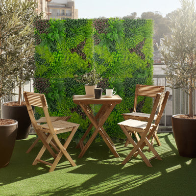 Outdoor patio set with wooden chairs and table against a green wall.