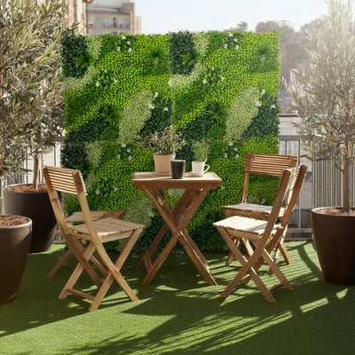 Outdoor balcony seating set with a greenery backdrop and potted plants.