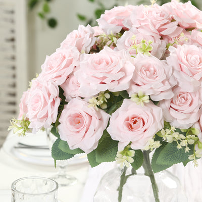 Pink artificial rose bouquet in a glass vase.