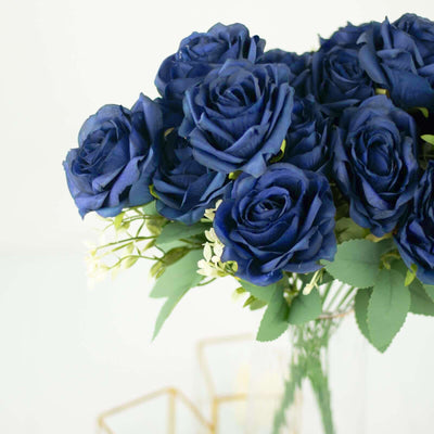 Blue artificial roses bouquet in a clear vase.
