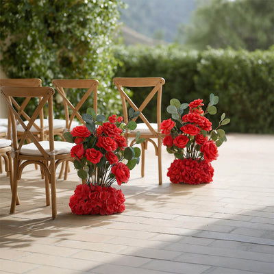 Outdoor wedding chairs with red rose floral arrangements on a patio