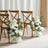 White floral arrangements beside wooden chairs in a stylish setting.