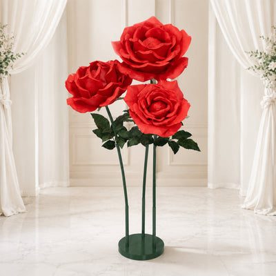 Oversized red rose floral sculpture on green stand in elegant room