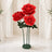 Oversized red rose floral sculpture on green stand in elegant room
