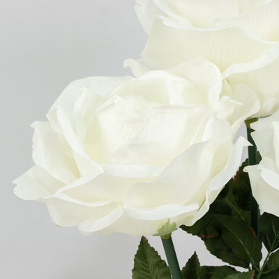 White roses in soft pastel bloom against a light gray background#whtbkgd