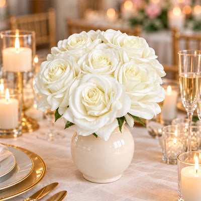 White rose centerpiece in a vase on an elegant candlelit wedding table