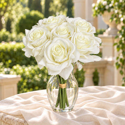White rose bouquet in glass vase on a soft fabric table outdoors