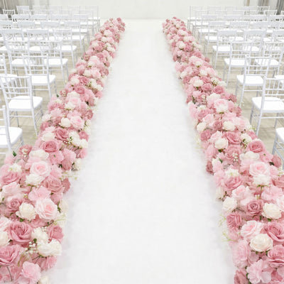 Pink floral wedding aisle with white chairs in a bright ceremony venue