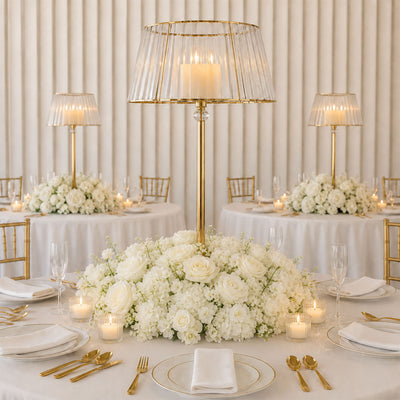 Elegant wedding table centerpiece with white flowers and gold candlelit decor