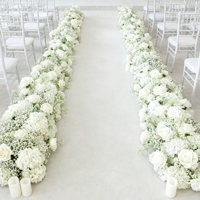 White floral wedding aisle decor with roses and candles.