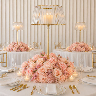 Elegant pastel pink floral wedding table setting with gold candlelit decor