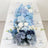 Blue floral table runner with white plates and clear ribbed glasses on a dining table