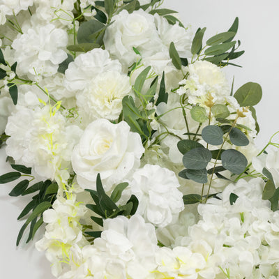 White floral arrangement with roses, hydrangeas, and eucalyptus greenery