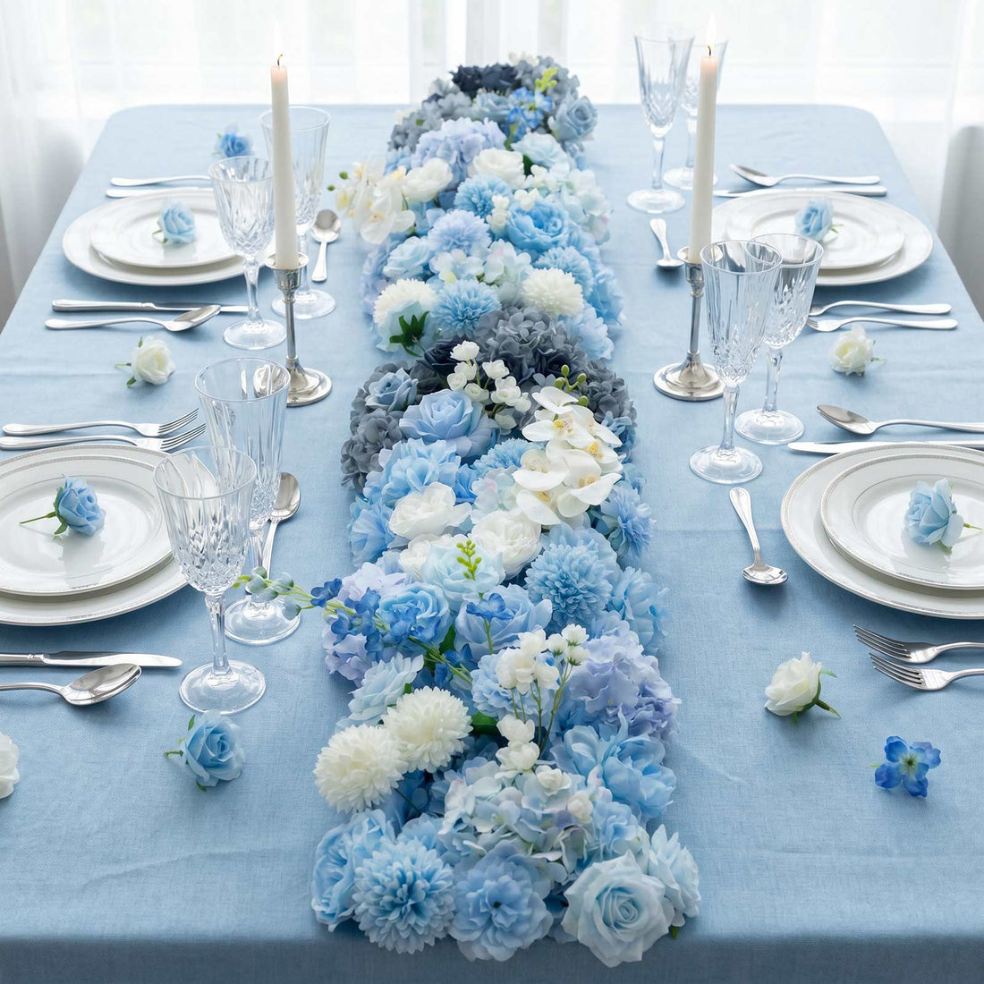 Blue floral table setting with elegant glassware and candles